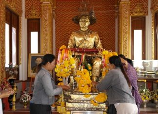 At the King Taksin statue, people present fruit, pig heads, ducks and chicken, while others gild the statue with gold leaf.